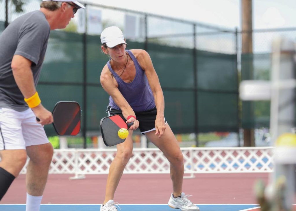 Two people playing pickleball outside